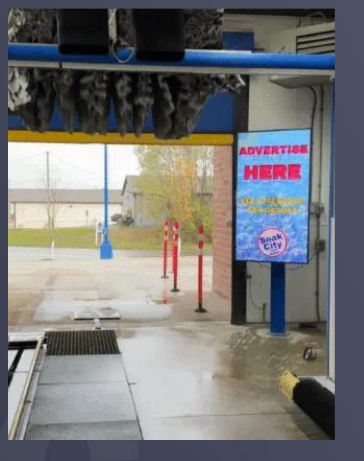 Actual car wash tunnel exit with vertical digital advertising display, from the Gigantic Media presentation